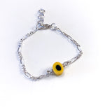 Gult, fargerikt armbånd til barn. Design inspirert av godteri. Selges i sett med smykke, perfekt dåpsgave eller navnefest. Justerbar lengde, passer også større barn