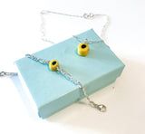 Gult, fargerikt armbånd og smykke til barn. Design inspirert av godteri. Selges i sett med smykke og armbånd, perfekt dåpsgave eller navnefest. Justerbar lengde, passer også større barn