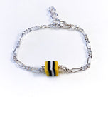 Gult, fargerikt armbånd til barn. Design inspirert av godteri. Selges i sett med smykke, perfekt dåpsgave eller navnefest. Justerbar lengde, passer også større barn